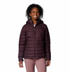 Woman wearing a purple puffer jacket on a white background