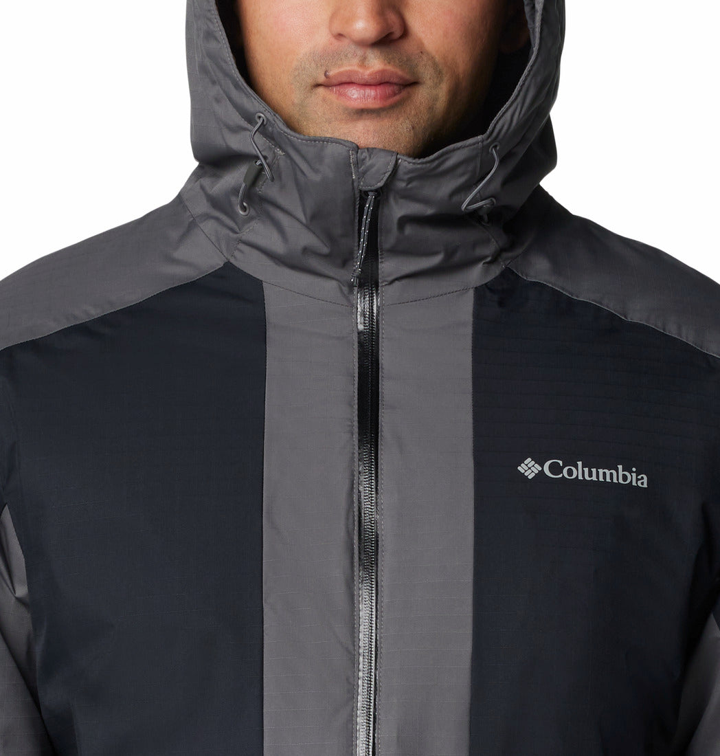 Person wearing a Columbia jacket with a hood on a plain background