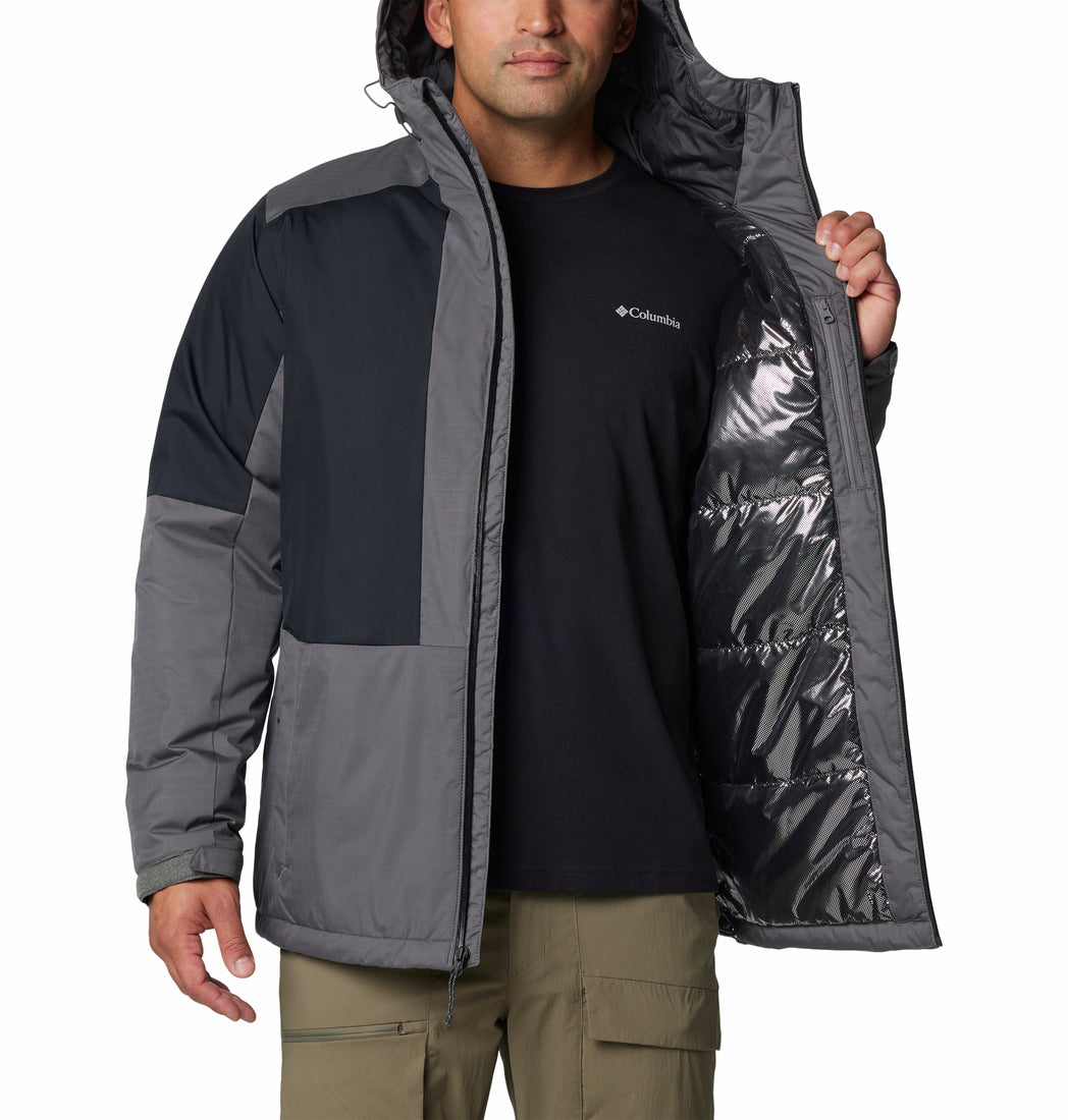 Person wearing a Columbia jacket with a black shirt and green pants on a white background