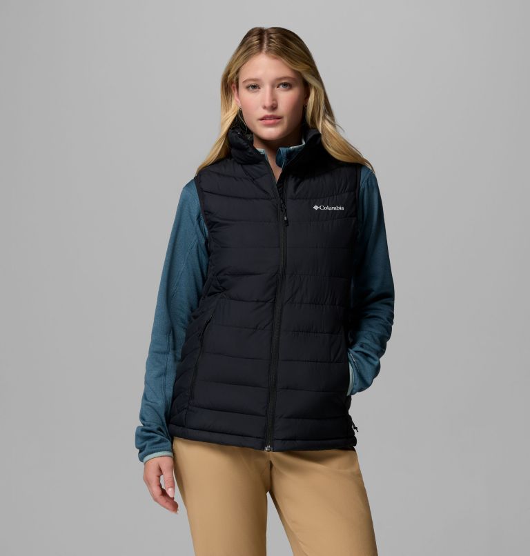 Woman wearing a black Columbia vest on a gray background