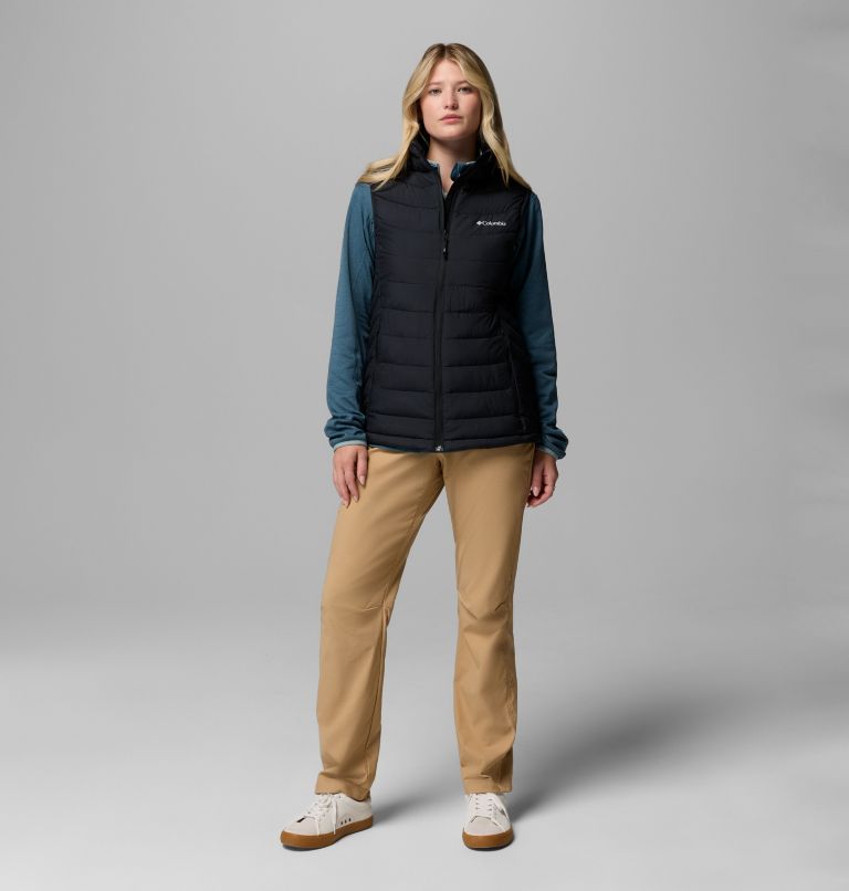 Person wearing a black puffer vest over a teal long-sleeve shirt on a gray background