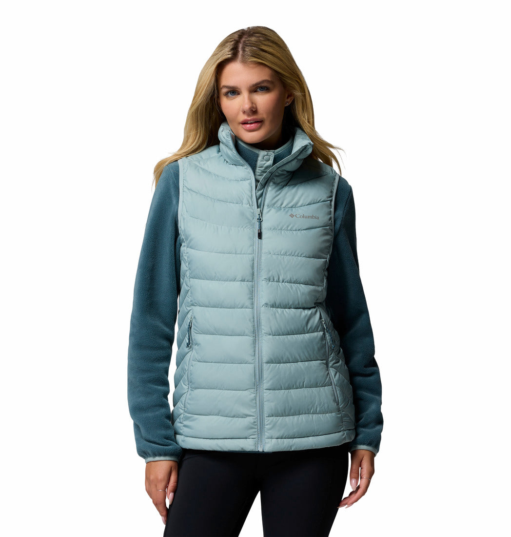 Woman wearing a light blue puffer vest on a white background