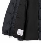 Black puffer jacket with a brand label on a white background
