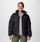 Person wearing a black puffer jacket with Columbia logo on a white background