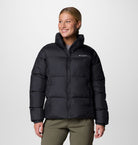 Person wearing a black puffer jacket with Columbia logo on a white background