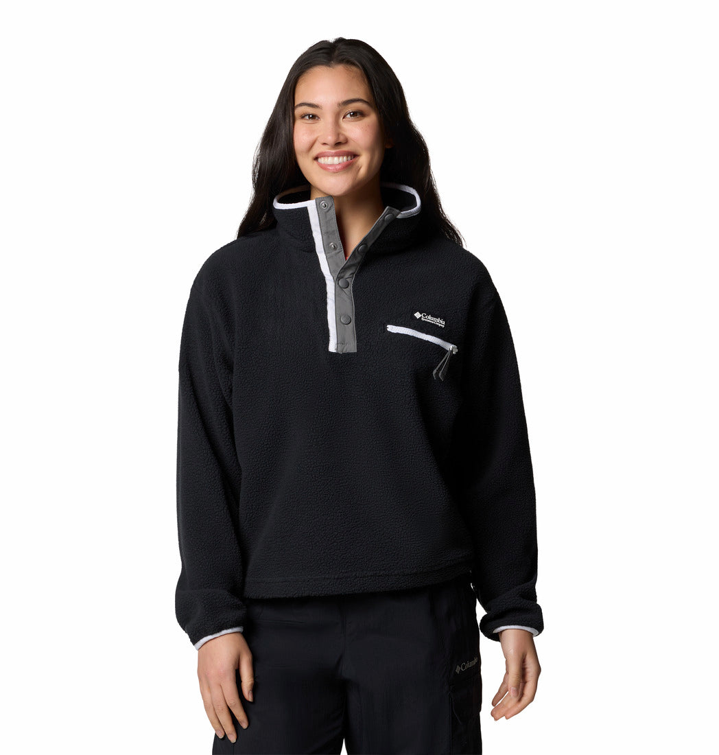 Person wearing a black pullover with a brand logo on a white background
