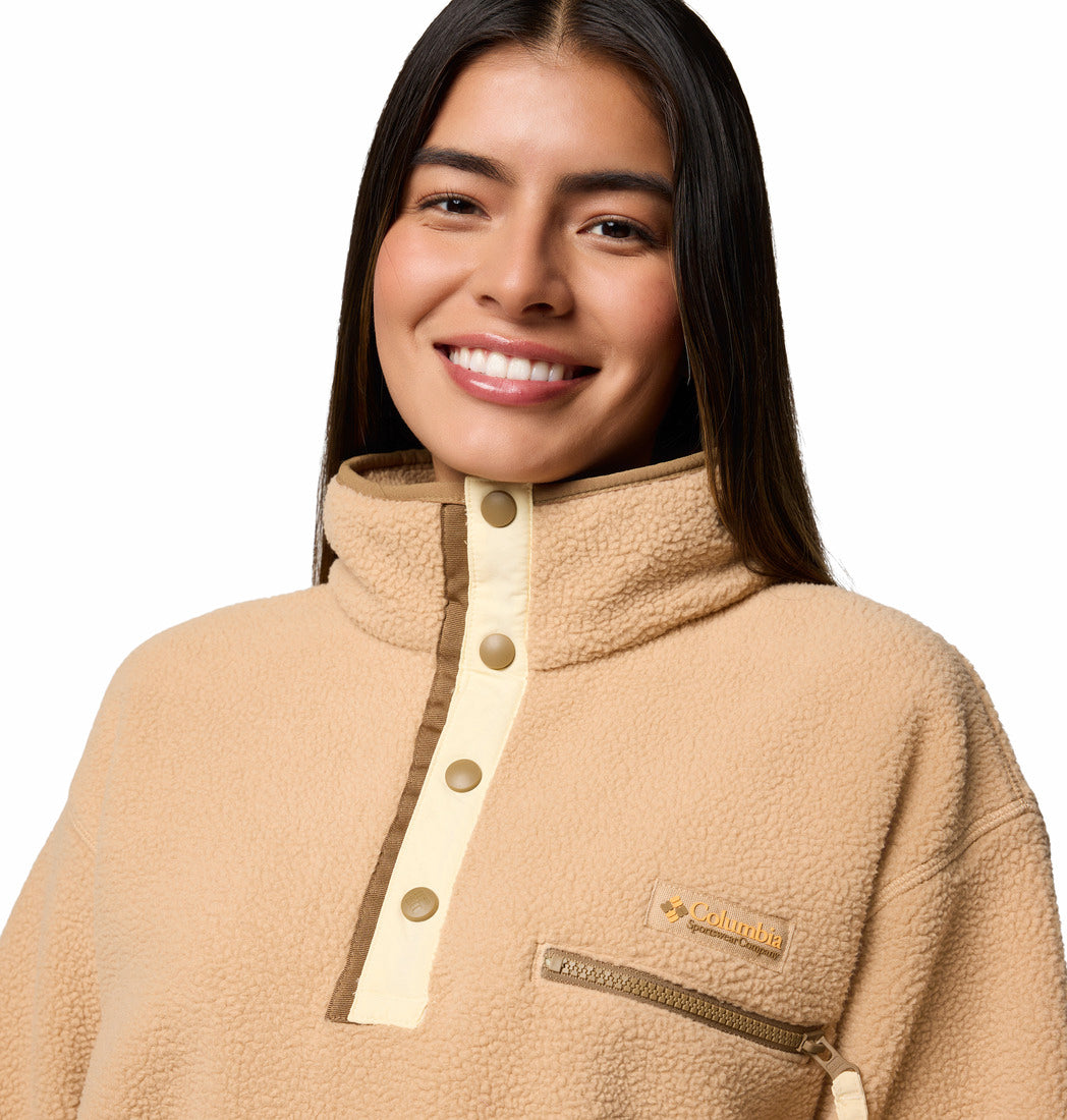 Woman wearing a beige fleece pullover with a Columbia logo on a white background