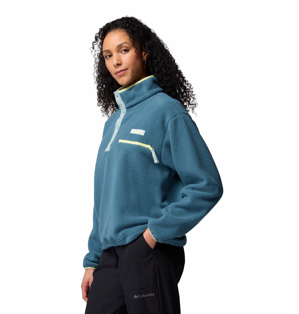 Person wearing a teal pullover with a white background