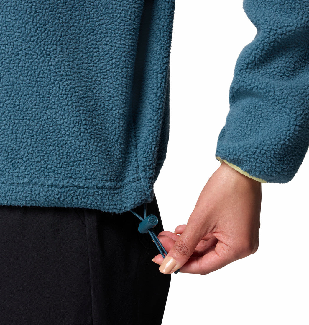 Person wearing a blue fleece jacket with a hand adjusting the drawstring.