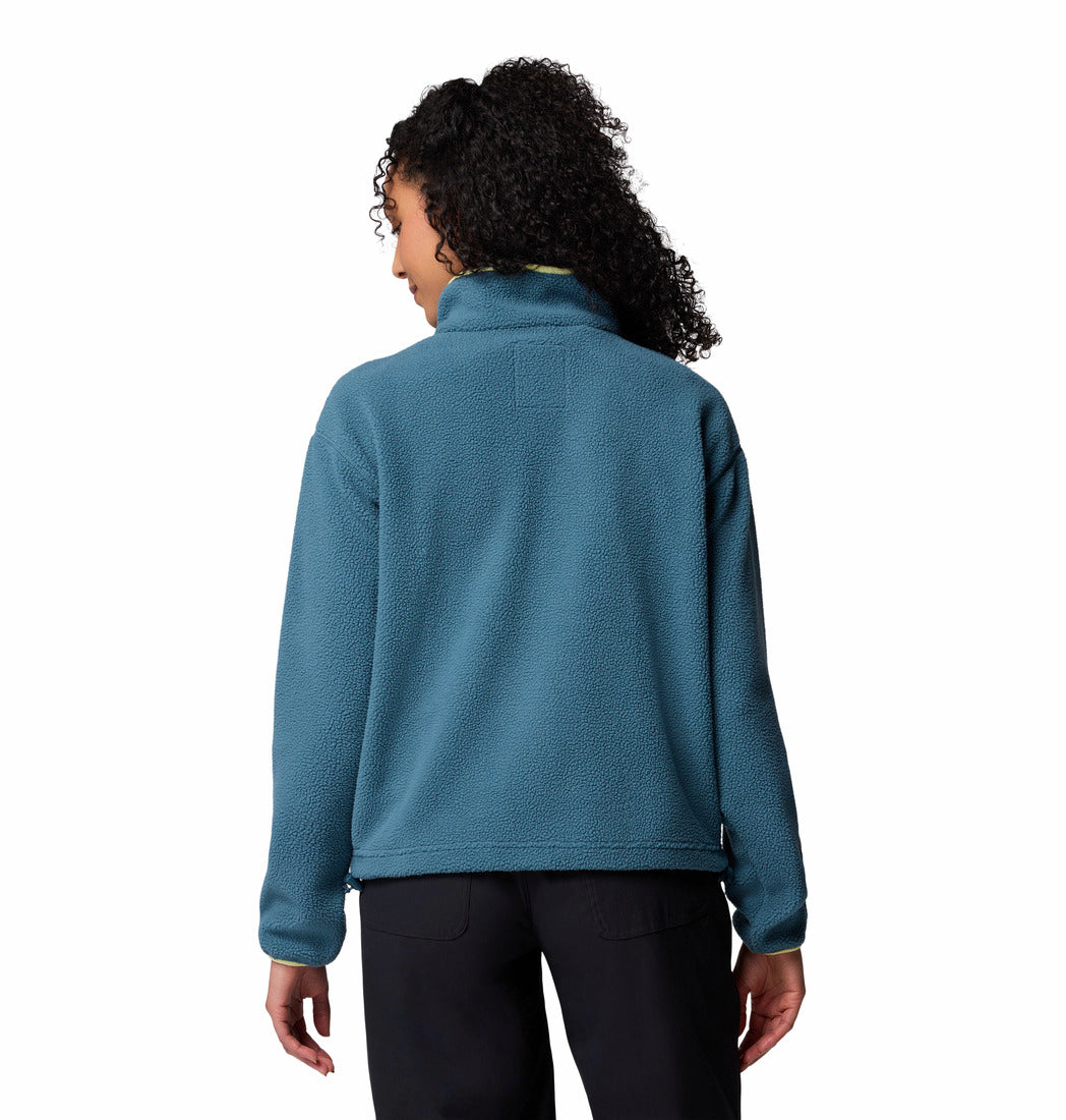 Person wearing a teal fleece jacket on a white background