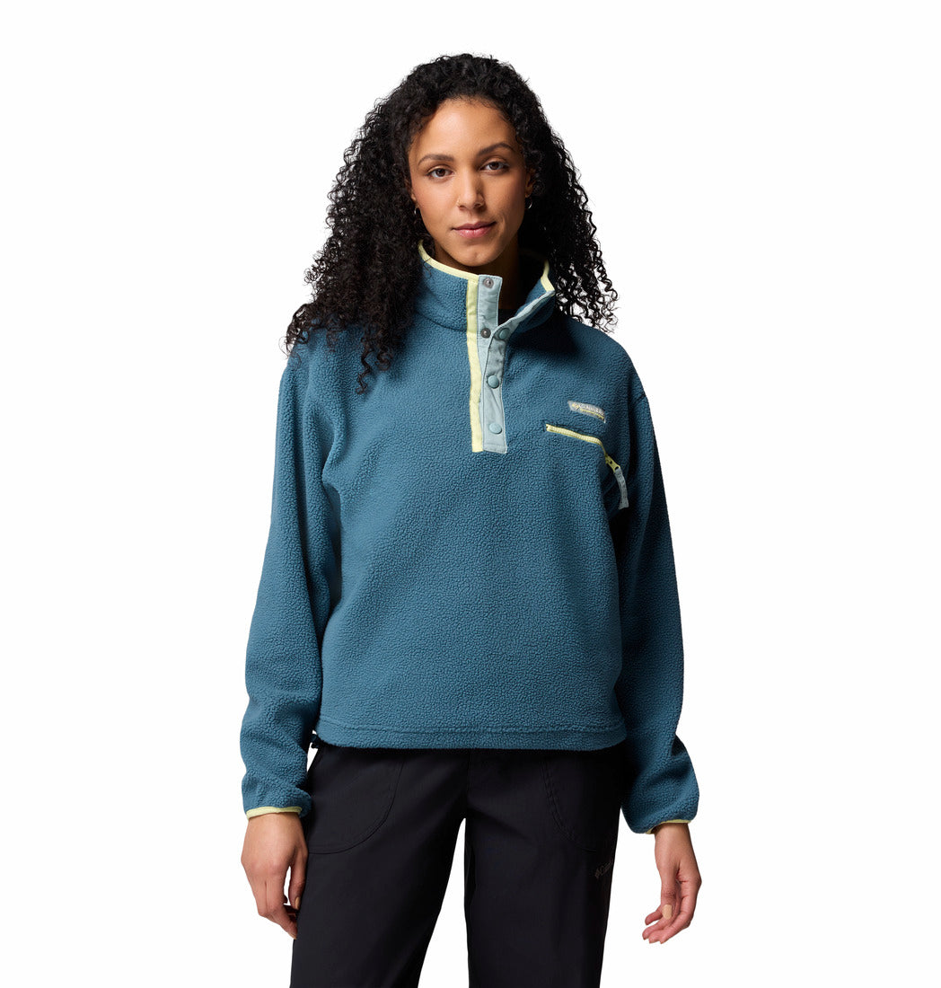 Woman wearing a teal pullover with a white background