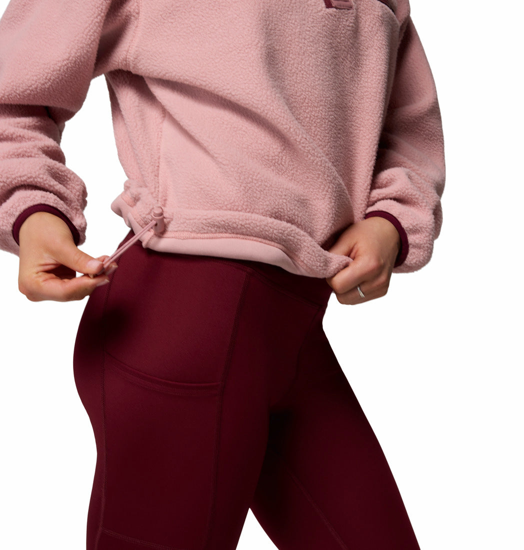 Person wearing a pink fleece jacket and maroon pants on a white background