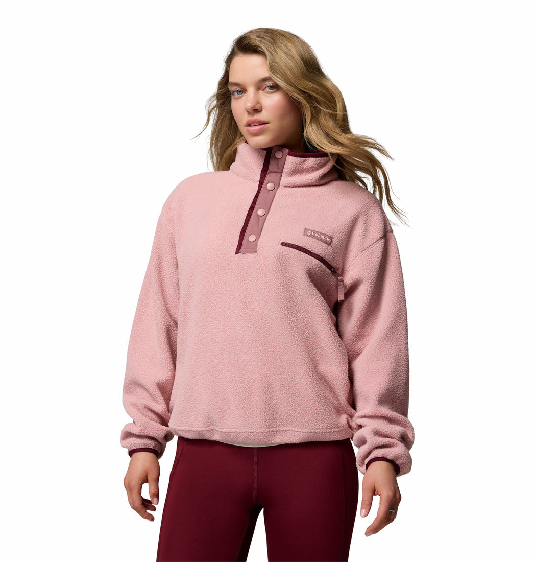 Woman wearing a pink pullover with a brand logo on a white background