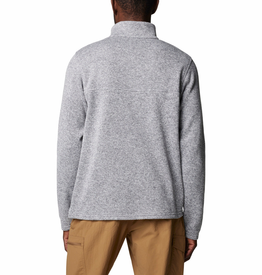 Person wearing a gray fleece pullover and beige pants on a white background