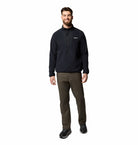 Man wearing a black pullover and green pants on a white background