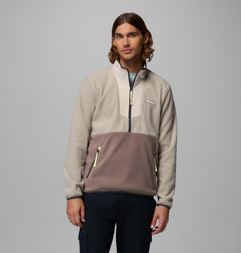 Man wearing a two-tone pullover with a gray and beige design on a gray background