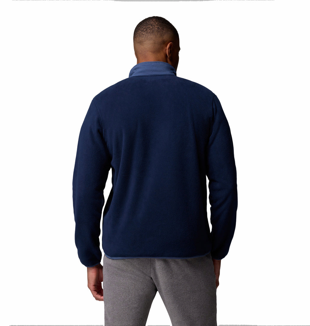 Man wearing a navy blue jacket and gray pants on a white background