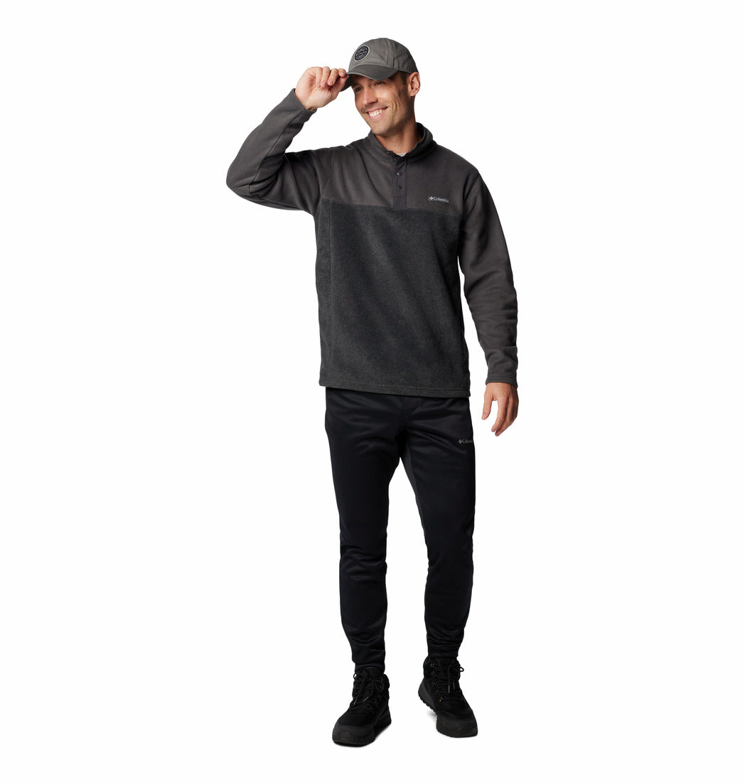 Man wearing a dark gray long-sleeve shirt and black pants on a white background