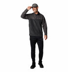 Man wearing a dark gray long-sleeve shirt and black pants on a white background