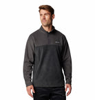 Man wearing a dark gray pullover with a brand logo on a white background