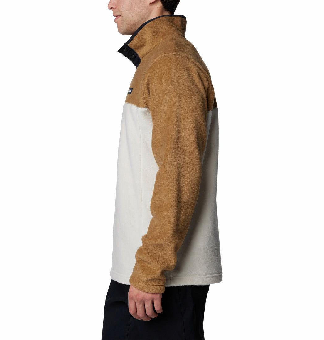 Side view of a person wearing a brown and beige pullover with a visible brand logo.