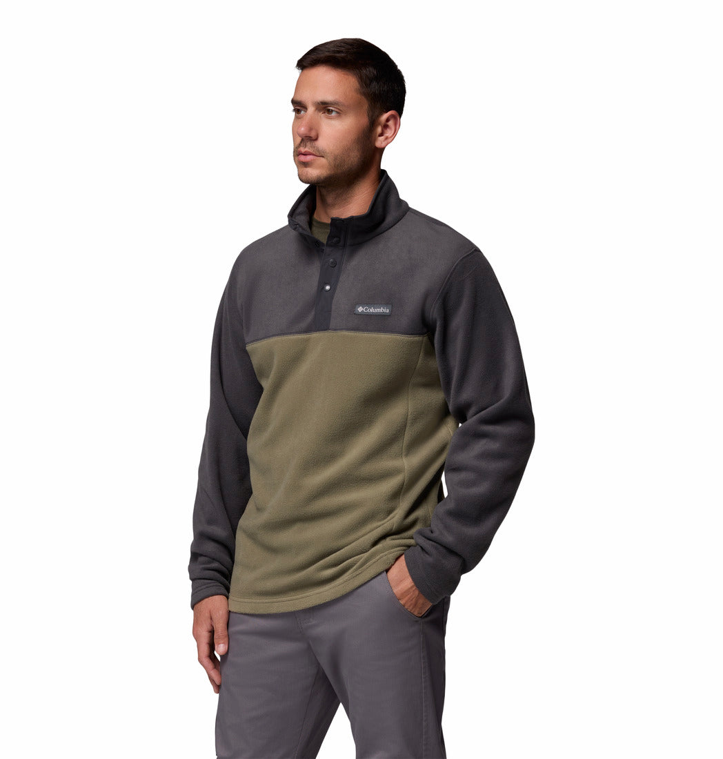 Man wearing a two-tone pullover with a visible brand logo on a white background