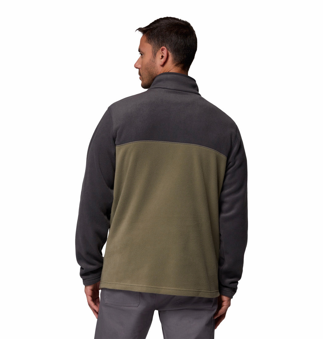 Man wearing a two-tone jacket with dark gray and green sections on a white background