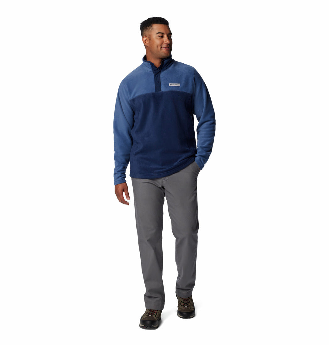 Man wearing a blue pullover and gray pants on a white background