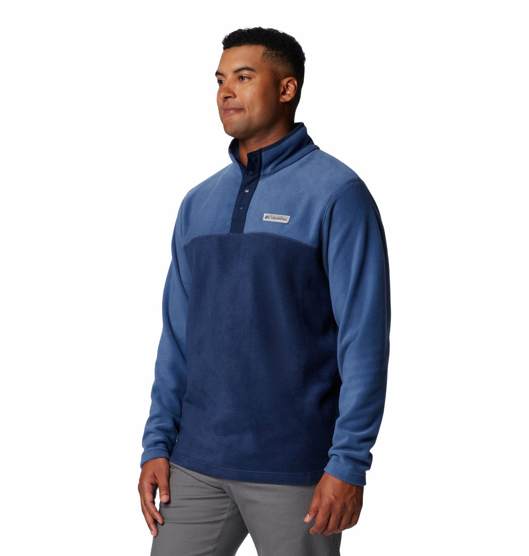 Man wearing a blue pullover with a visible brand logo on a white background