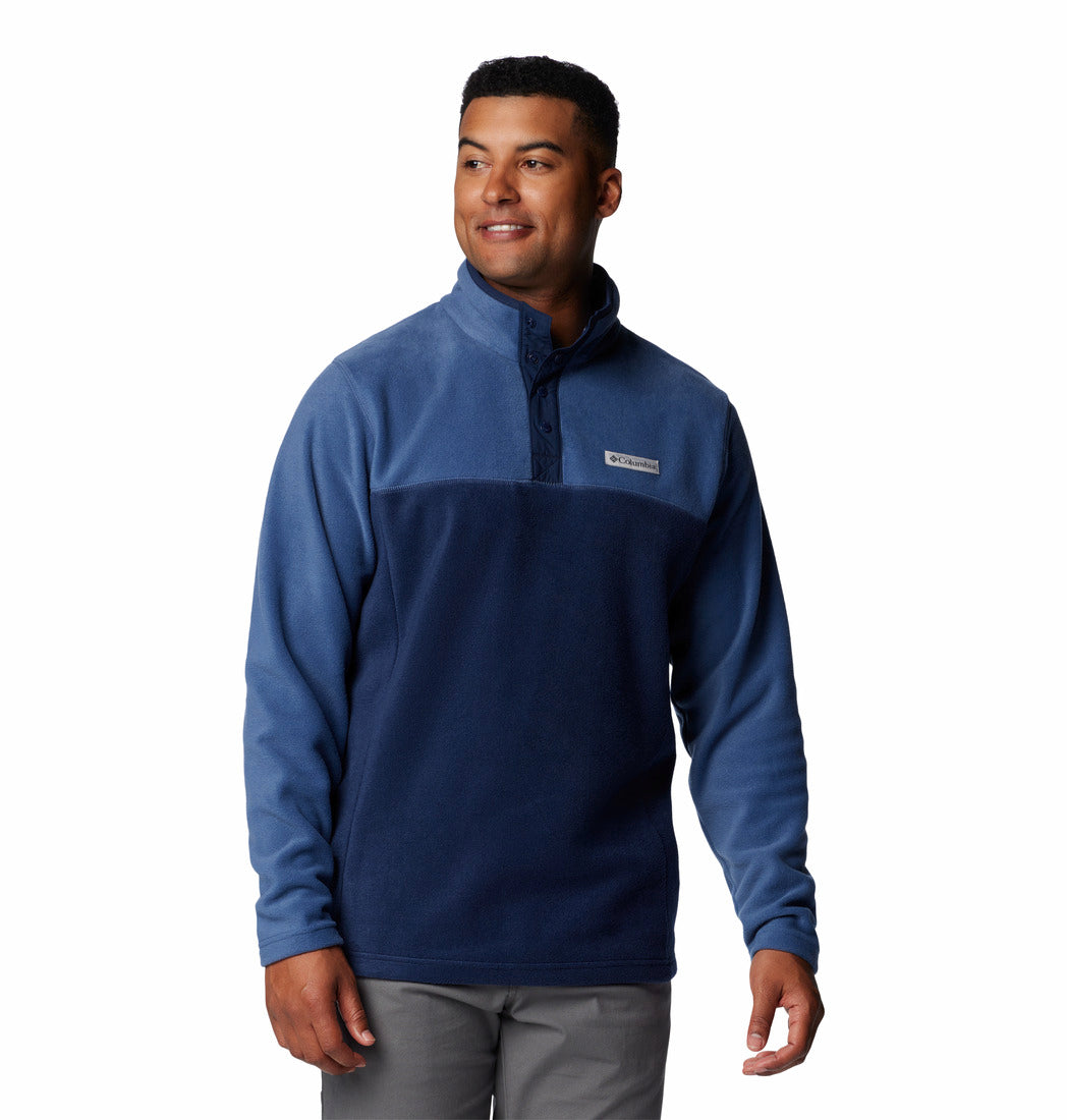 Man wearing a blue pullover with a brand logo on a white background