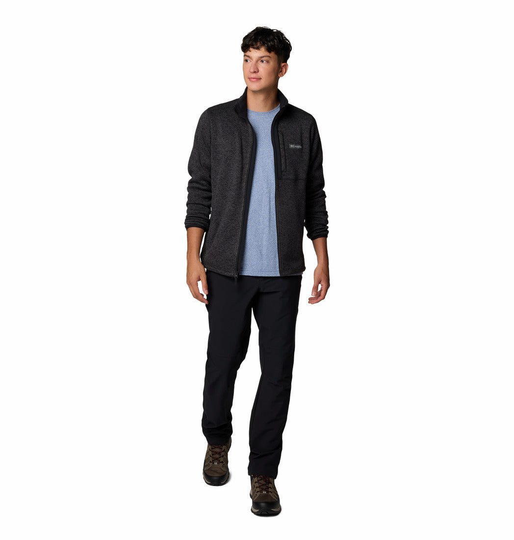 Person wearing a black jacket, blue shirt, and black pants on a white background