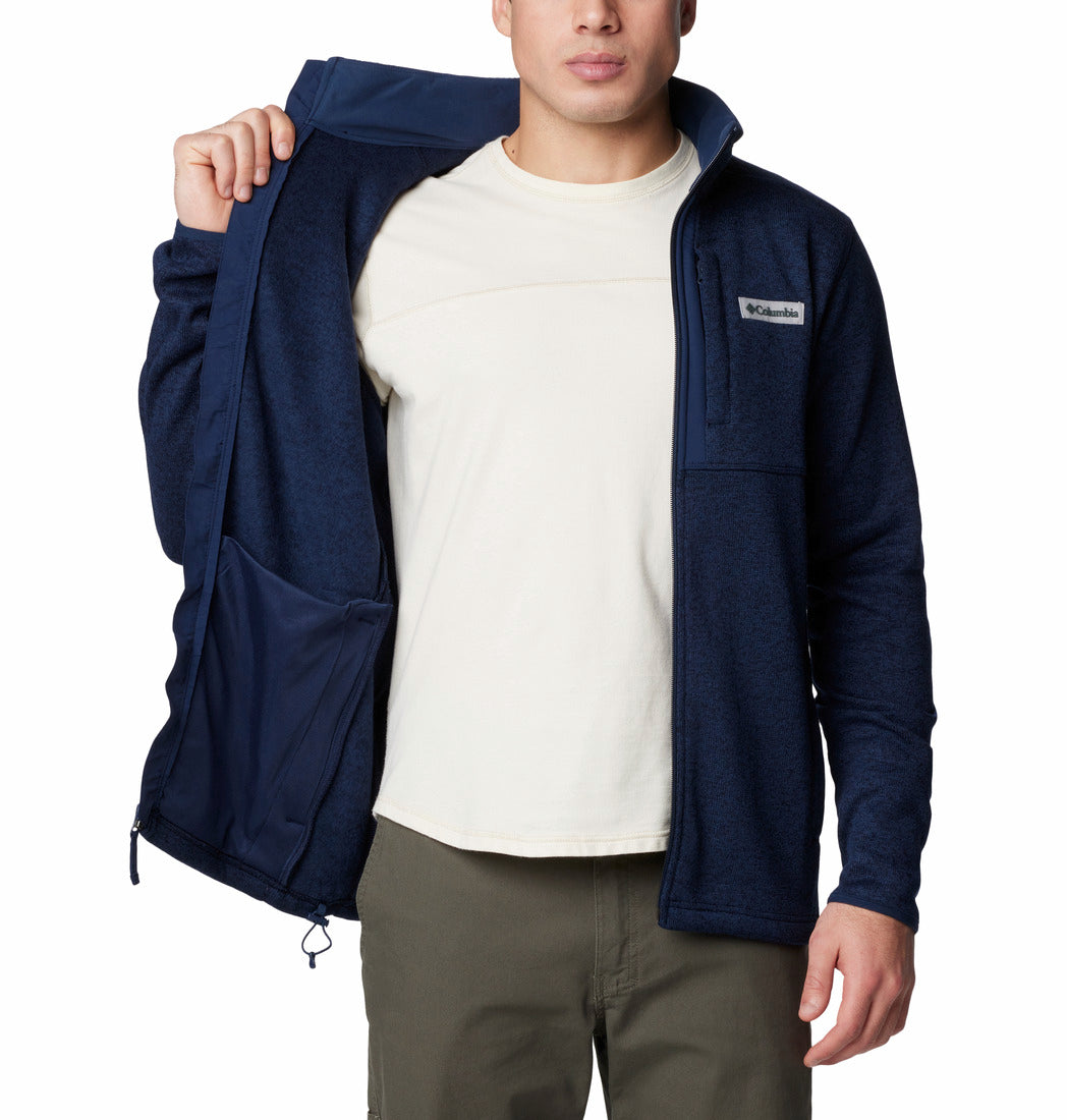 Person wearing a navy blue fleece jacket over a white shirt on a white background