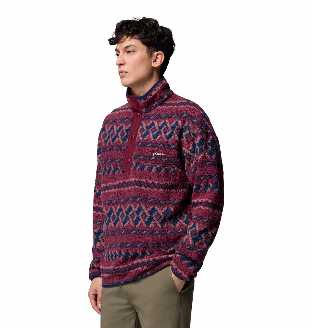 Person wearing a patterned pullover with a visible brand logo on a white background