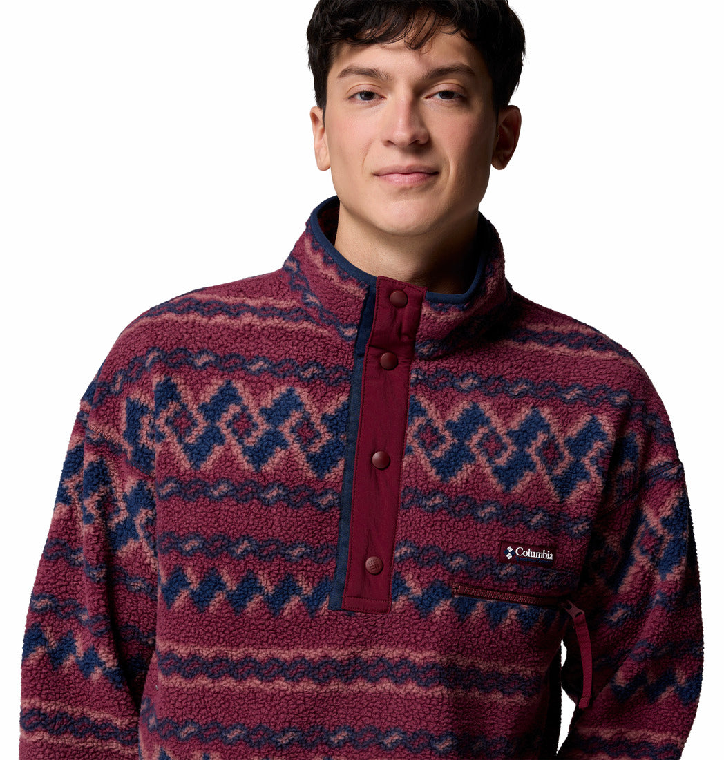 Person wearing a patterned maroon and blue pullover with Columbia logo.