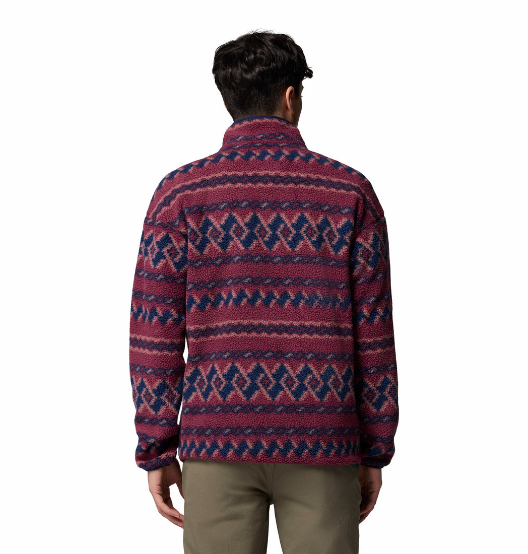Person wearing a patterned sweater on a white background
