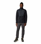Man wearing a black fleece and pants on a white background