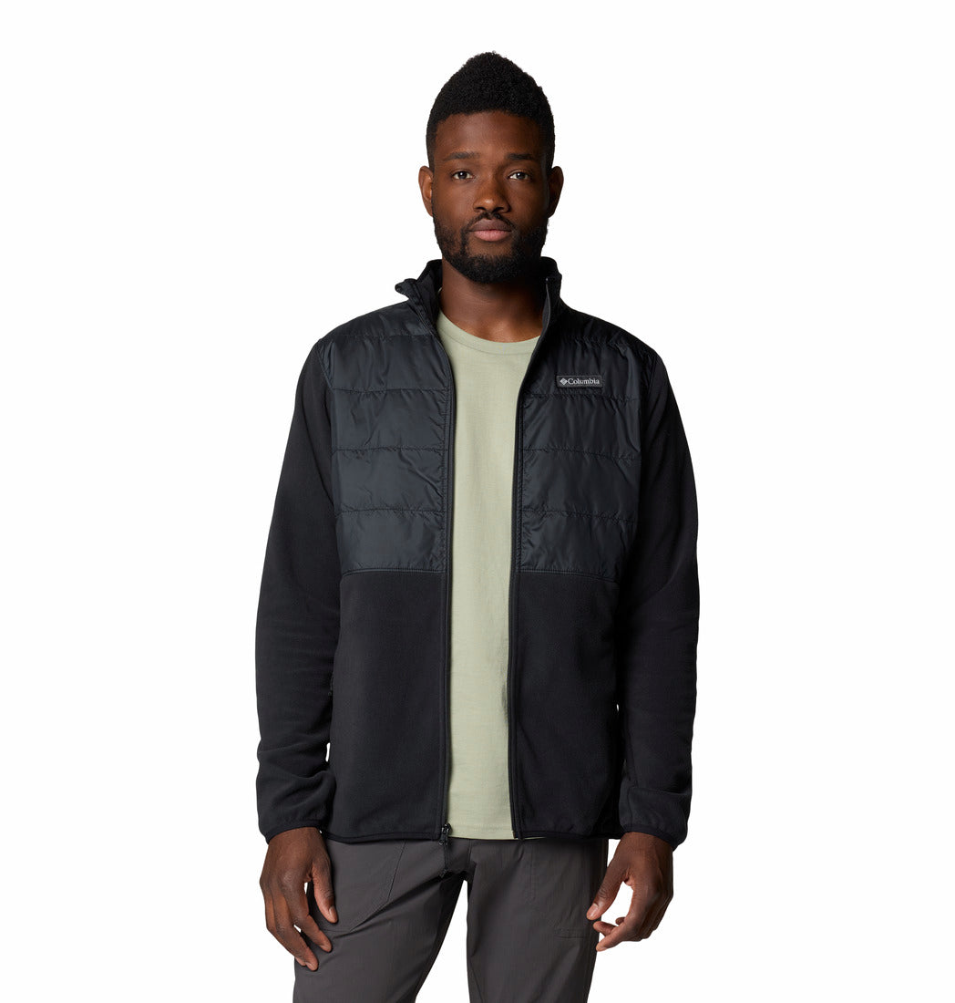 Man wearing a black jacket with a visible brand logo on a white background