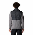 Person wearing a two-tone jacket with gray and black colors on a white background
