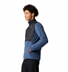 Person wearing a two-tone jacket with black and blue colors on a white background