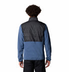 Person wearing a two-tone jacket with black and blue colors on a white background