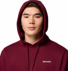 Person wearing a maroon hoodie with Columbia logo on a white background