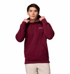 Person wearing a maroon hoodie with a brand logo on a white background