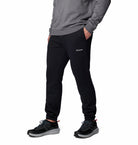 Person wearing black Columbia sweatpants on a white background