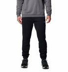 Person wearing black sweatpants and a gray sweatshirt on a white background