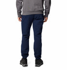 Person wearing a gray sweatshirt and navy blue pants on a white background