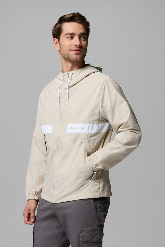 Man wearing a beige jacket with white accents on a gray background