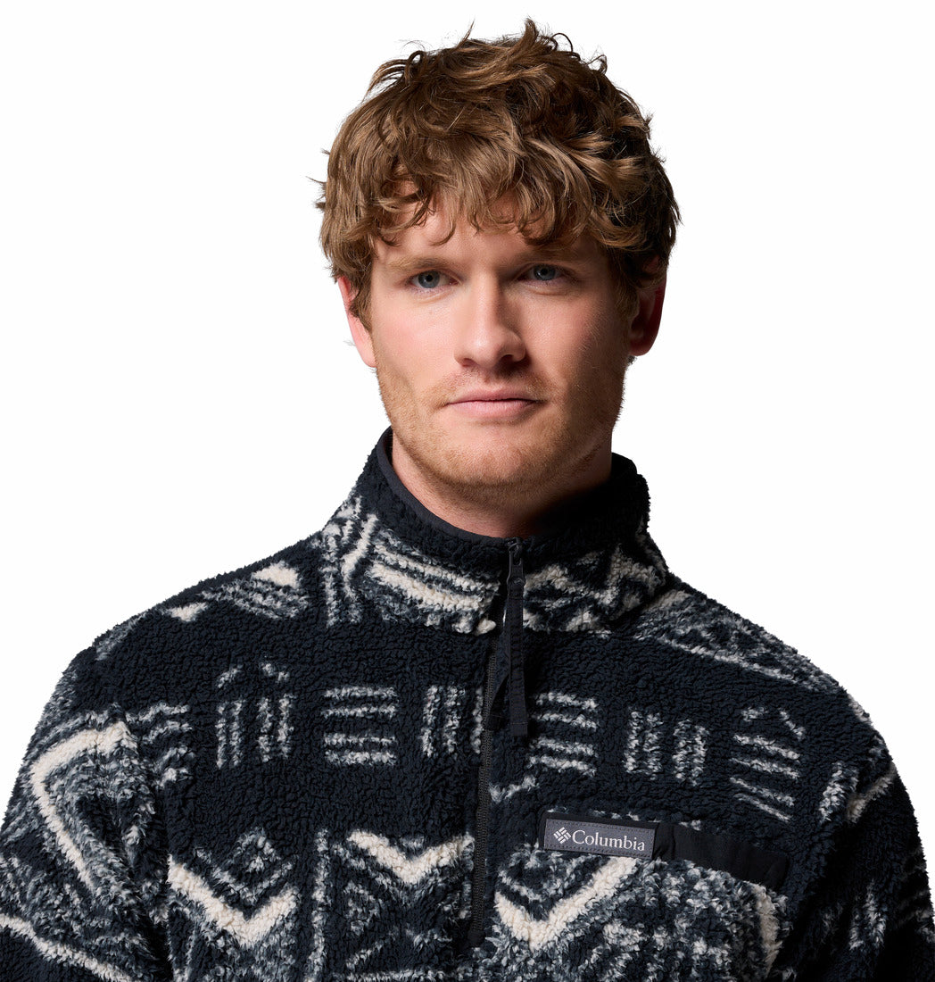 Man wearing a patterned pullover with Columbia logo on a white background