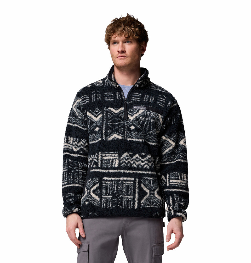 Man wearing a patterned black and white sweater on a white background
