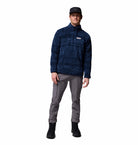 Person wearing a blue patterned fleece jacket, gray pants, and black boots on a white background