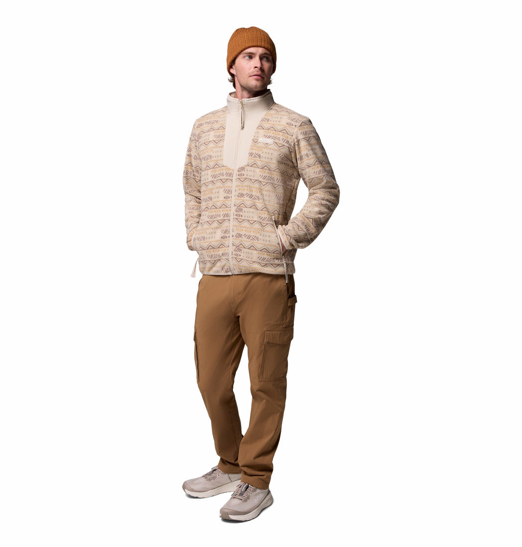 Man wearing a beige sweater, brown beanie, and tan pants on a white background